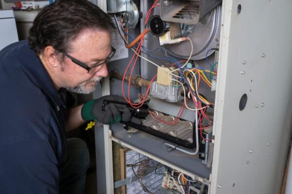 HVAC technician looking at heating unit