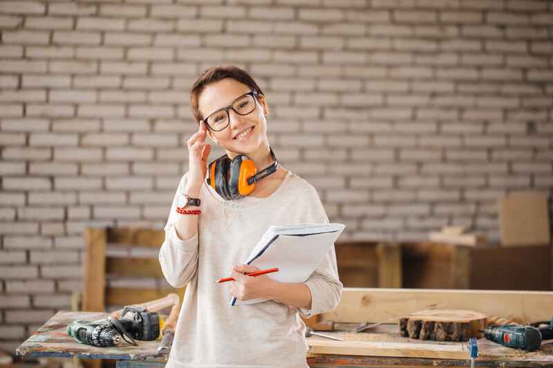 hardworking professional female worker with pen and tablet in workshop