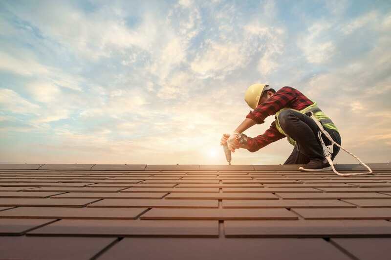 Roofer working in special protective work wear gloves