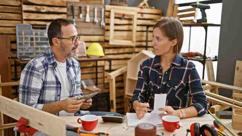 Two carpenter mates tackling accounting duties in a carpentry business, an inside look at the economy of woodworking
