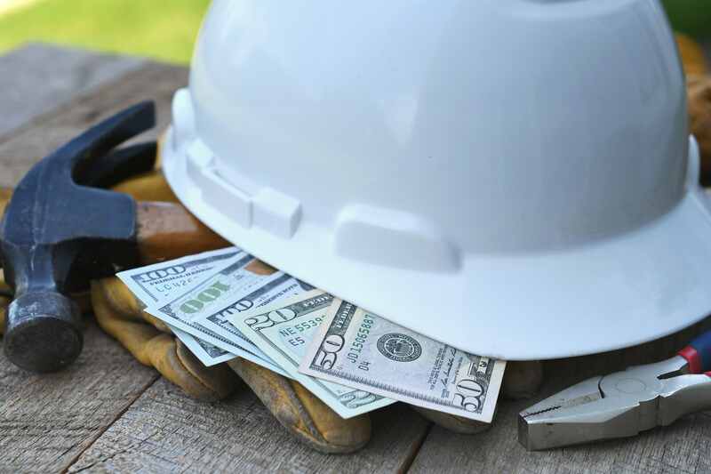 money bills hammer under construction helmet