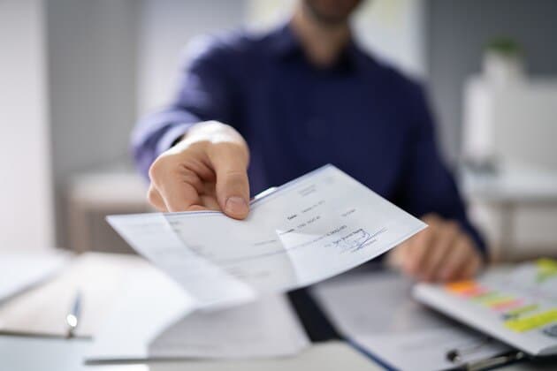 employee receiving paycheck with pay stub