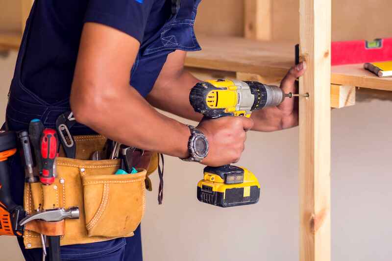 Handyman works with drill does repair