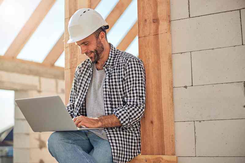 Male construction worker using his laptop