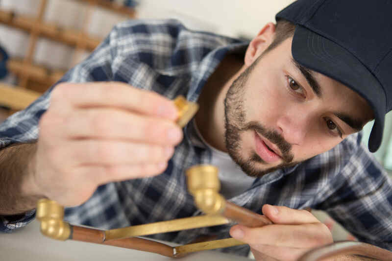 plumber working with pipes and fittings
