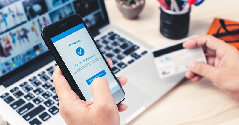 Hands holding smartphone and credit card to make online payment