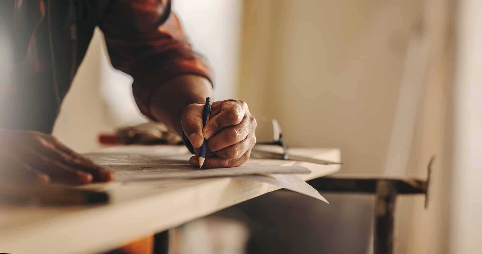 Hands of contractor with pencil, marking paper