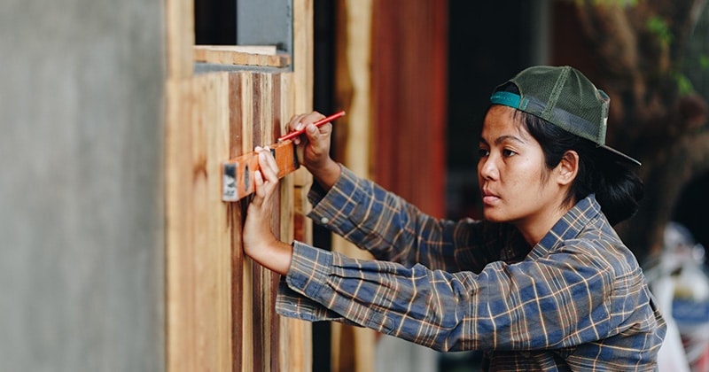 Home renovation pro using a spirit level and marking the wall with a pencil