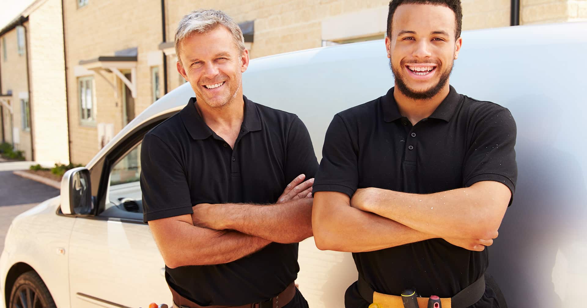 Two trade pros in front of their van