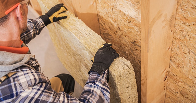 Contractor installing mineral wool insulator