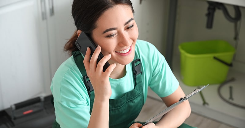 Plumber on mobile phone in a kitchen