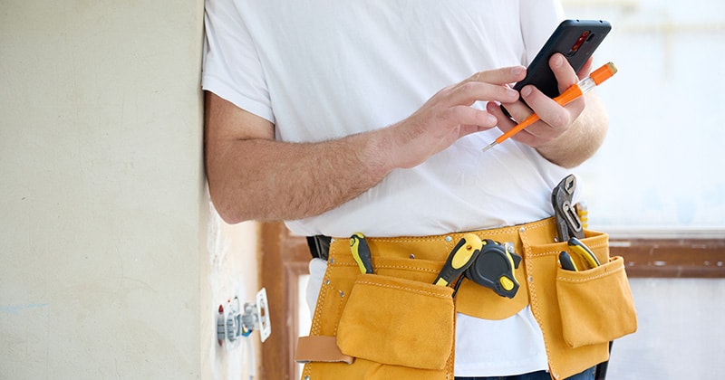 Handyman checks phone