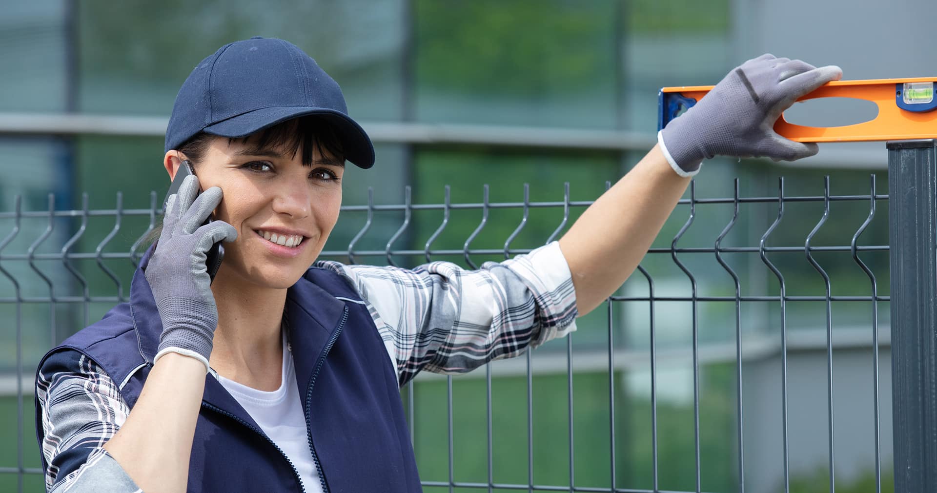 Worker installing welded metal mesh fence