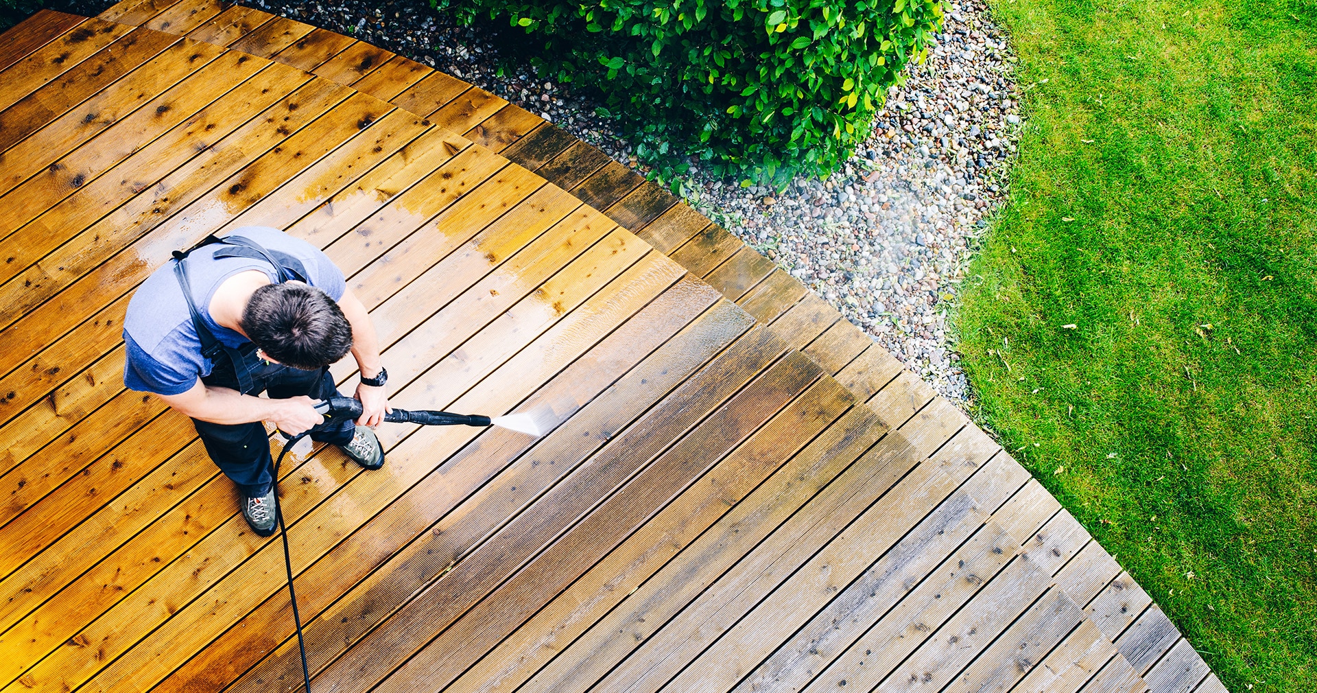 Above view of contractor cleaning deck with power washer