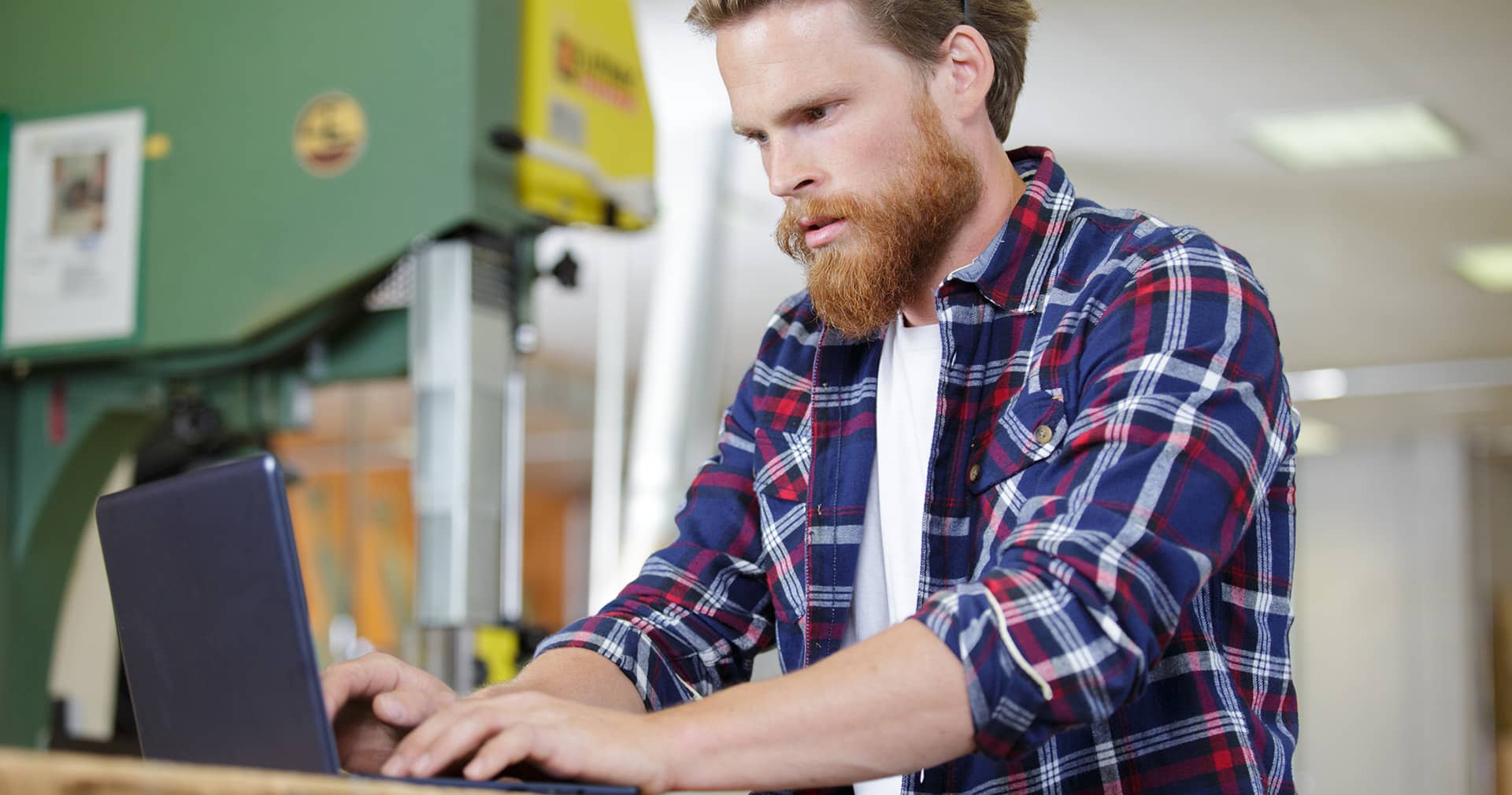 Contractor using laptop in workshop