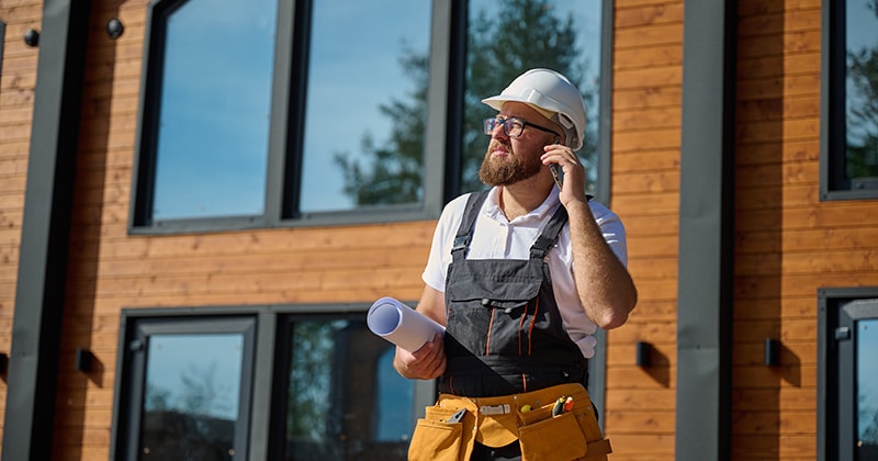 Project manager for residential construction project in front of home
