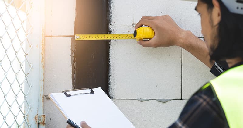 Construction pro taking measurements with tape measure