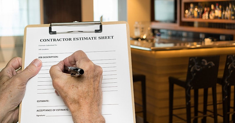 Contractor filling out paper estimate by hand