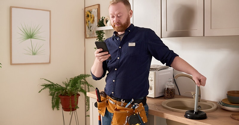 Contractor works on estimate on phone while onsite