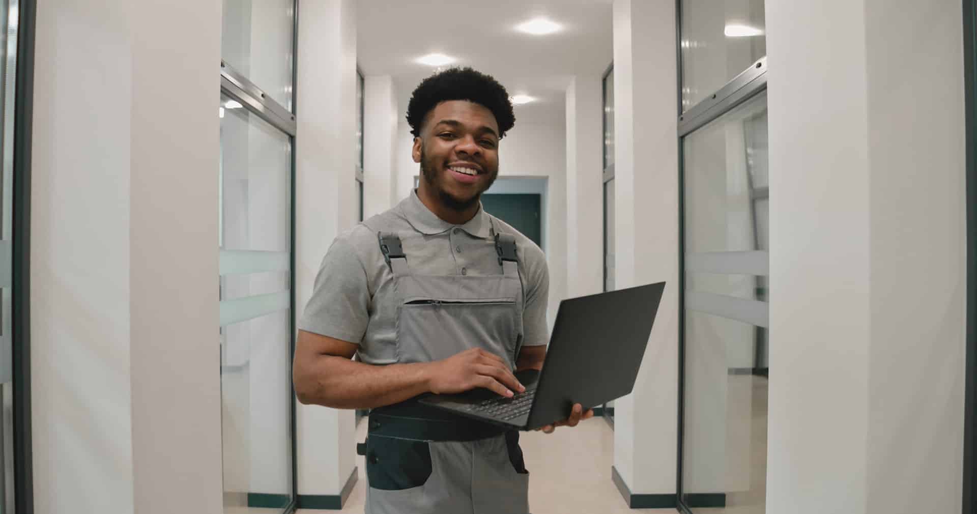 Contractor works on laptop in commercial office space