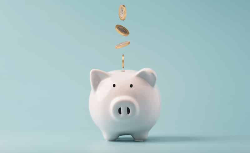 Coins falling to white piggy saving