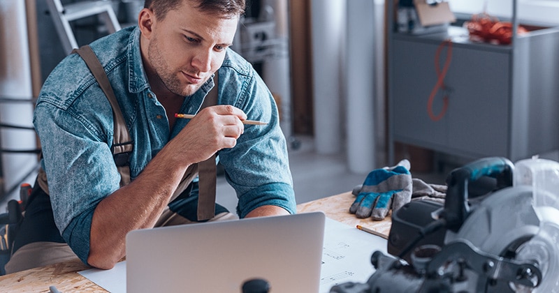 Contractor in work space looking at laptop
