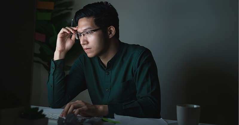 Contractor working on computer in home office late at night