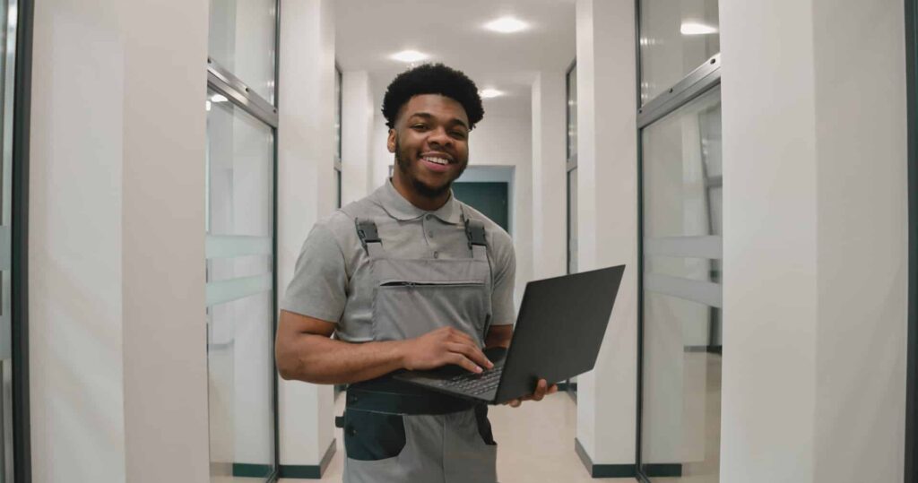 Contractor works on laptop in commercial office space