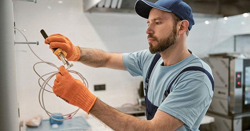 Electrician repairing electric cable with pliers