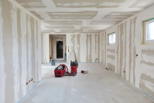 Empty living room after putty work on walls and ceiling in a new build house