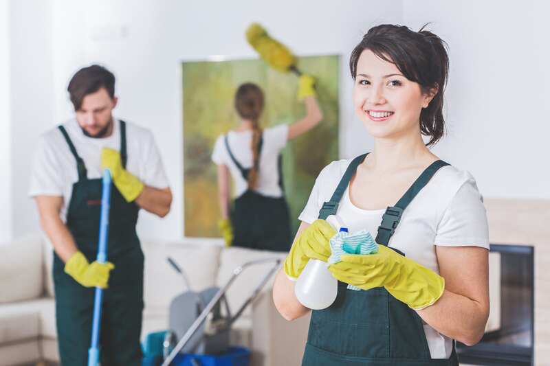 Group of young, hard-working professional cleaners in dirty apartment