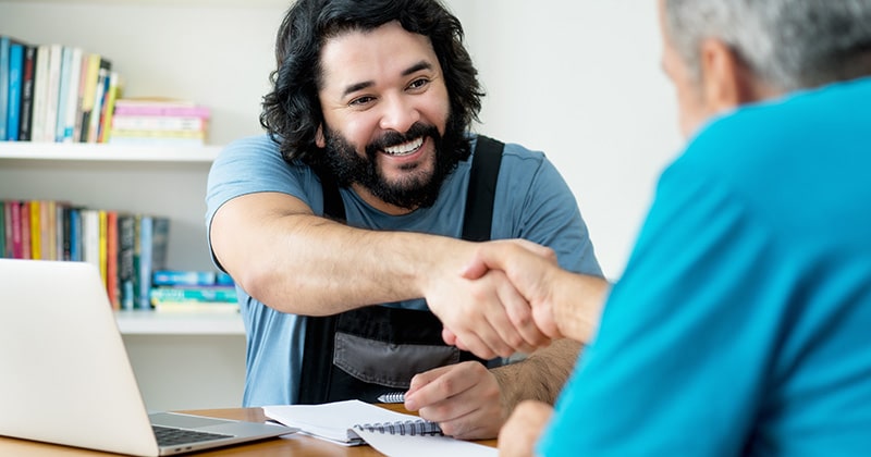 Handyman and customer shake hands