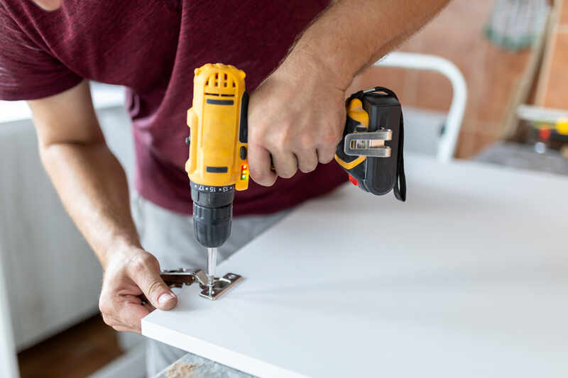 Handyman holding cordless screwdriver machine