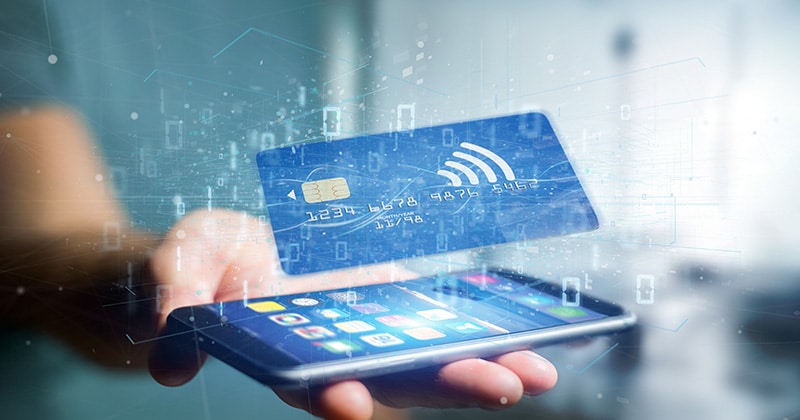 Holding phone with contactless credit card payment concept