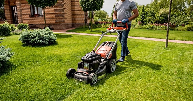 Landscaping contractor mowing lawn for commercial space