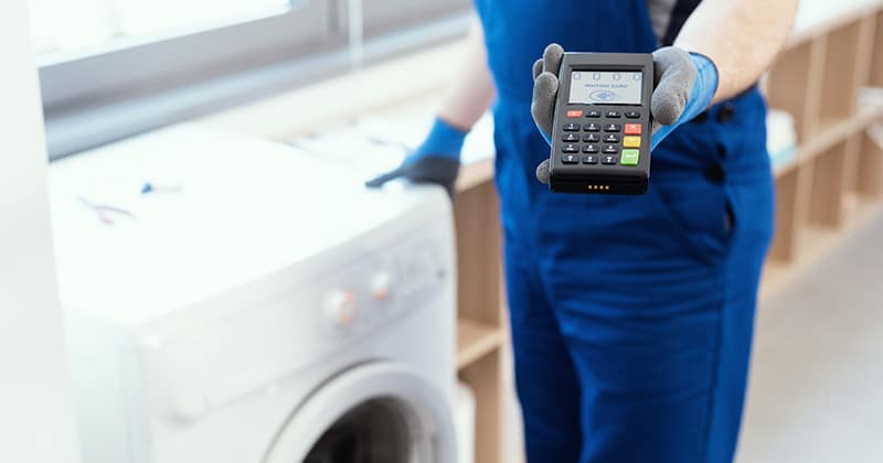 Repairman holding a point-of-sale terminal to collect payment