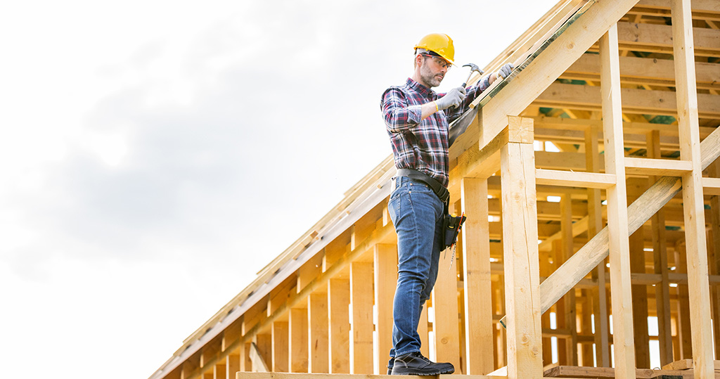 Roofer working on roof structure at construction site