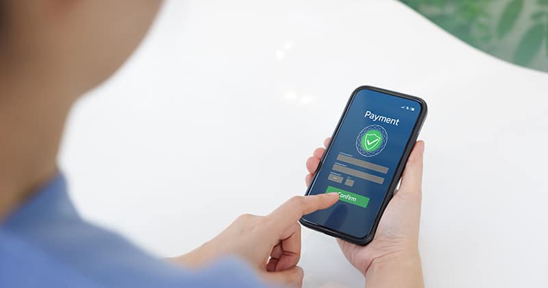 View of hands using smartphone to make online payment