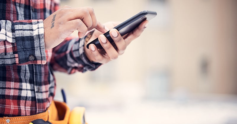 Zoom in handyman's hands using smartphone