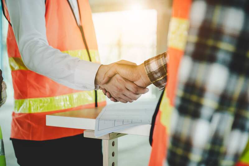 construction worker and contractor shaking hands