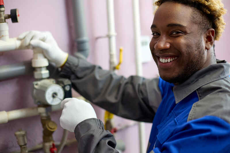 happy plumber working smiling at the camera