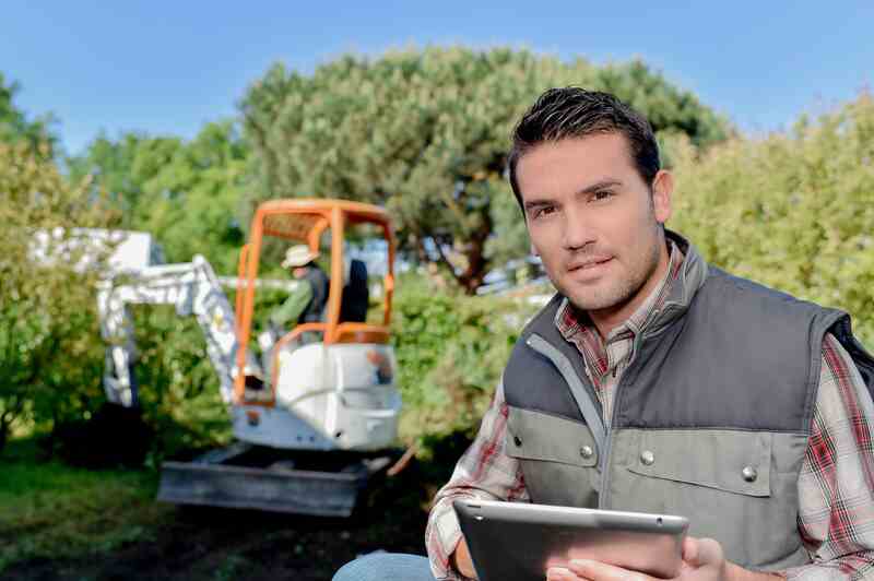 man holding a tablet outdoors